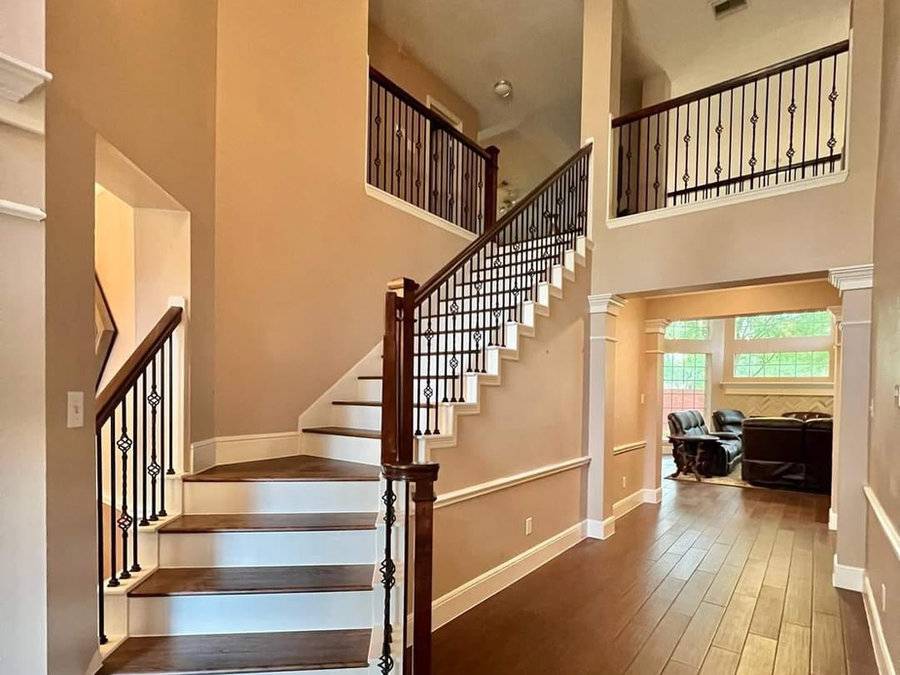 Staircase with iron balusters and hardwood treads