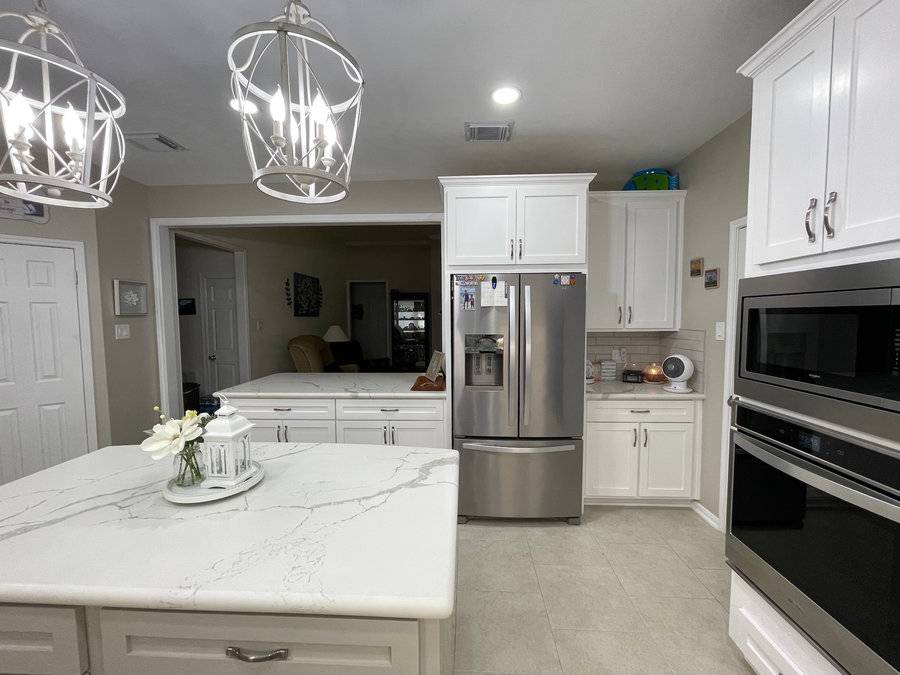 White kitchen with quartz waterfall island and pendant lighting