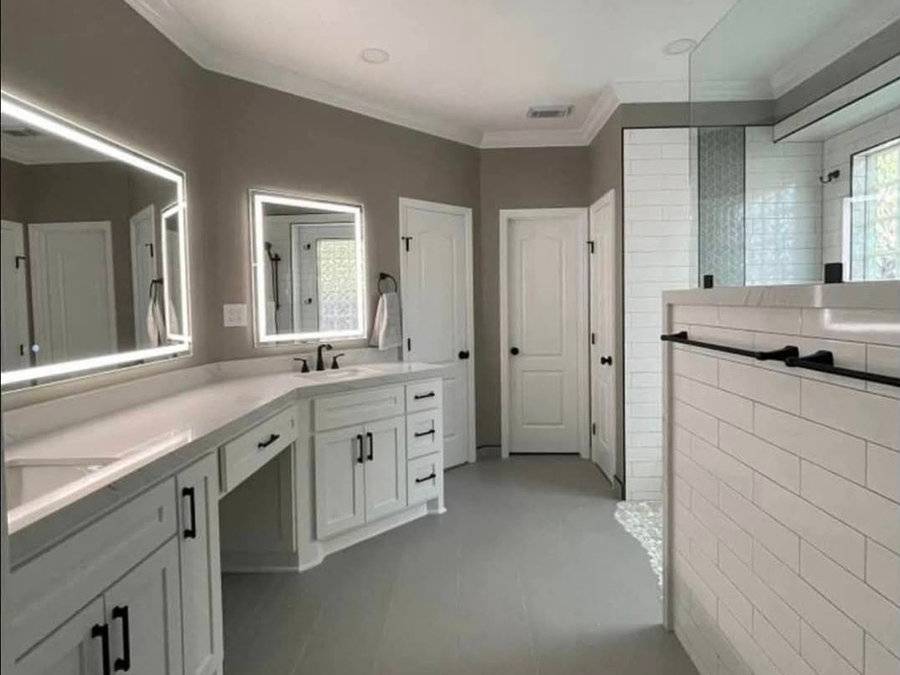 Bathroom with backlit mirrors and a long vanity