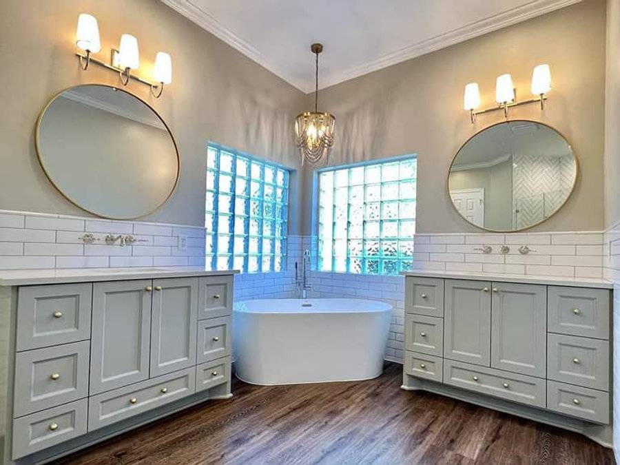 Primary bathroom after: freestanding tub, twin vanities and round mirrors